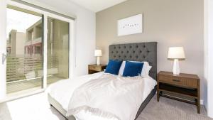 a bedroom with a bed with blue pillows and a window at Landing Modern Apartment with Amazing Amenities (ID3724) in Las Vegas