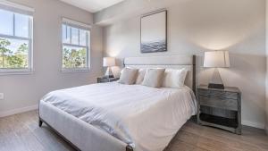 Fort Myers Villas的住宿－Landing Modern Apartment with Amazing Amenities (ID8094X36)，卧室设有一张白色大床和两个窗户。