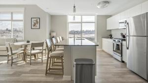 a kitchen and dining room with a table and a refrigerator at Landing Modern Apartment with Amazing Amenities (ID1348X886) in Sandy