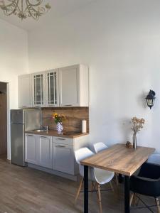 a kitchen with white cabinets and a wooden table at Apartments Karuza Center of old town Vis in Vis