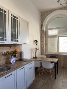 a kitchen with white cabinets and a table and a sink at Apartments Karuza Center of old town Vis in Vis