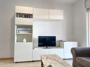 a living room with a white entertainment center with a tv at Apartment Picasso in Vilanova i la Geltrú