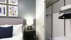 een slaapkamer met een bed, een lamp en een spiegel bij Landing Modern Apartment with Amazing Amenities (ID5061X74) in Portland