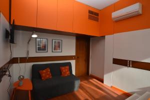 ein Wohnzimmer mit Sofa und orangefarbener Decke in der Unterkunft The Serra Vision in Ivrea