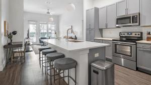 a kitchen with a large island with bar stools at Landing Modern Apartment with Amazing Amenities (ID1384X699) in Orlando
