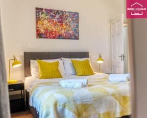 a bedroom with a large bed with yellow pillows at Wyndcliff Huge House By Digbeth-City Centre-M6-NEC with 5 Bedrooms-6 Separate Beds and 2 Bathrooms & WC - Contractors-Insurance Stays-Families and and Flexible Long Stays in Birmingham