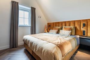 een slaapkamer met een groot bed met een houten hoofdeinde bij Het-Boothuys in Harderwijk