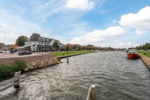 Łódź zakotwiczona jest w rzece obok budynku w obiekcie Het-Boothuys w mieście Harderwijk