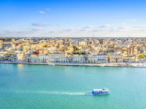 a boat in the water in front of a city at Residence Lori in Brindisi