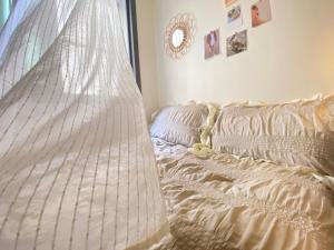 an unmade bed in a room with a window at Morning room RED PANDA GUESTHOUSE in Seoul