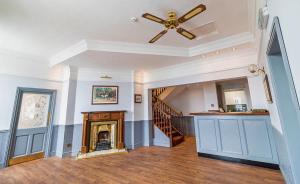 a living room with a ceiling fan and a fireplace at The Windmill Hotel - Alford in Alford