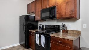 een keuken met een zwarte kachel en een magnetron bij Landing Modern Apartment with Amazing Amenities (ID7606X42) in Columbus