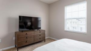 een slaapkamer met een flatscreen-tv op een dressoir bij Landing Modern Apartment with Amazing Amenities (ID7606X42) in Columbus