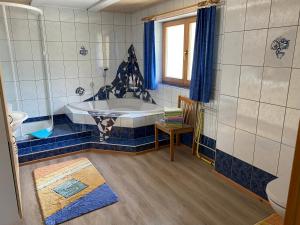 ein Badezimmer mit einer Badewanne, einem Tisch und einem Stuhl in der Unterkunft Gemütliche, geräumige Familienunterkunft - Stofbauer in Rangersdorf