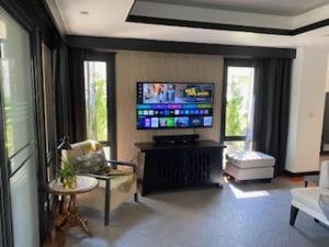 a living room with a flat screen tv on a wall at 2Bed Villa - Sleeps 4 - Poolside Wifi Near Beach in Layan Beach