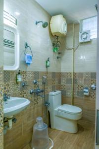 a bathroom with a toilet and a sink at Rithikha Inn Crest in Chennai