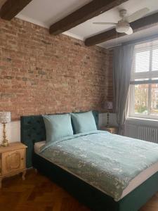 a bedroom with a bed and a brick wall at Apartments PSD - Anny Łajming 1C in Słupsk