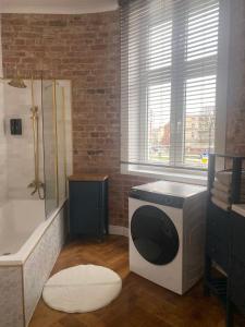 a bathroom with a shower and a washing machine at Apartments PSD - Anny Łajming 1C in Słupsk