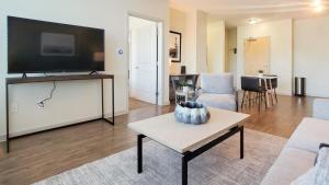 Landing Modern Apartment with Amazing Amenities (ID3173X70) في دنفر: غرفة معيشة مع تلفزيون بشاشة مسطحة كبيرة