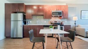 Landing Modern Apartment with Amazing Amenities (ID3173X70) في دنفر: مطبخ مع طاولة بيضاء وثلاجة