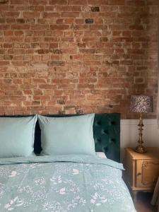 a bedroom with a brick wall and a bed at Apartments PSD - Anny Łajming 1C in Słupsk