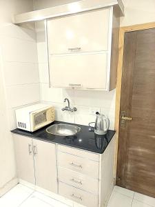 a small kitchen with a microwave and a sink at Al fazal Tower in Rāmkot