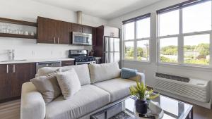 a living room with a white couch in a kitchen at Landing Modern Apartment with Amazing Amenities (ID1357X457) in Portland