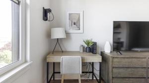a desk with a lamp and a television in a room at Landing Modern Apartment with Amazing Amenities (ID1357X457) in Portland