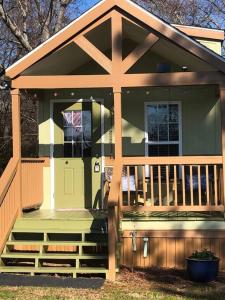 una piccola casa con portico anteriore con porta d'ingresso di Cozy and Peaceful Tiny House on a 100-acre Farm a Lewisville