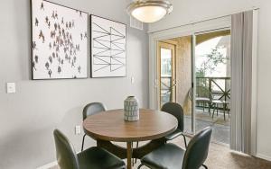 a dining room with a wooden table and green chairs at Landing Modern Apartment with Amazing Amenities (ID7950X63) in Tucson