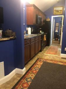 una cucina con pareti blu, armadi in legno e parete blu di Cozy and Peaceful Tiny House on a 100-acre Farm a Lewisville