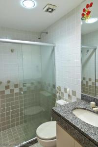 y baño con ducha, aseo y lavamanos. en Apartamento Porto Real Angra Dos Reis, en Mangaratiba