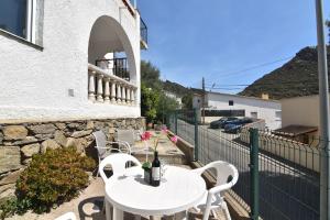 eine Terrasse mit einem weißen Tisch und Stühlen sowie ein Gebäude in der Unterkunft RNET - Casa del Sol Roses Costa Brava in Roses
