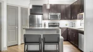 una cocina con encimera y 2 sillas. en Landing Modern Apartment with Amazing Amenities (ID883), en Birmingham