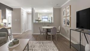 uma sala de estar com mesa e cadeiras e uma sala de estar em Landing Modern Apartment with Amazing Amenities (ID1204X607) em Charlotte