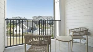- un balcon avec vue doté de 2 chaises et d'une table dans l'établissement Landing Modern Apartment with Amazing Amenities (ID1377X491), à Pflugerville