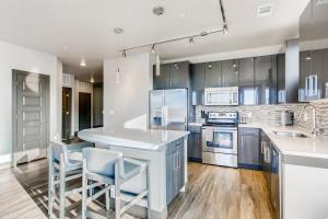 una cocina con armarios azules y electrodomésticos blancos en Landing Modern Apartment with Amazing Amenities (ID1963) en Denver
