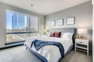 a bedroom with a bed and a large window at Landing Modern Apartment with Amazing Amenities (ID1963) in Denver