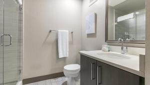 a bathroom with a sink and a toilet and a mirror at Landing Modern Apartment with Amazing Amenities (ID1960) in Denver