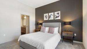 sypialnia z dużym białym łóżkiem i stolikiem nocnym w obiekcie Landing Modern Apartment with Amazing Amenities (ID8635X10) w mieście Irving