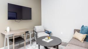 ein Wohnzimmer mit einem TV, einem Tisch und einem Stuhl in der Unterkunft Landing Modern Apartment with Amazing Amenities (ID6308X34) in Columbus