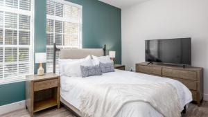 Landing Modern Apartment with Amazing Amenities (ID6308X34) في كولومبوس: غرفة نوم بسرير وتلفزيون بشاشة مسطحة