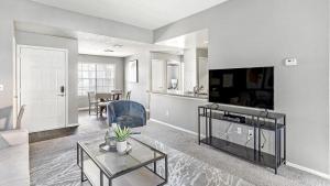 uma sala de estar com uma televisão e uma mesa em Landing Modern Apartment with Amazing Amenities (ID4301X28) em Las Vegas
