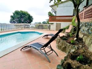 een paar stoelen naast een zwembad bij Catalunya Casas Ultimate tranquility in rural Costa Brava! in Tordera +15 foto's