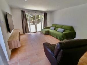 een woonkamer met een groene bank en een tafel bij Catalunya Casas Ultimate tranquility in rural Costa Brava! in Tordera