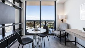 - une salle à manger avec une table, des chaises et de grandes fenêtres dans l'établissement Landing Modern Apartment with Amazing Amenities (ID870), à Fort Lauderdale