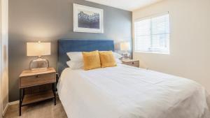 a bedroom with a large white bed with a blue headboard at Landing Modern Apartment with Amazing Amenities (ID8086X72) in Scottsdale