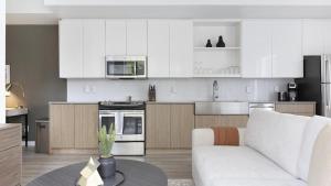 a kitchen with white cabinets and a white couch at Landing Modern Apartment with Amazing Amenities (ID9822X42) in Portland