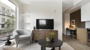 a living room with a tv and a chair and a table at Landing Modern Apartment with Amazing Amenities (ID9822X42) in Portland