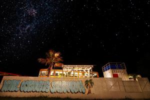 Hotel Ocean BUS Shirahama في Shioura: ليلة مفعمة بالنجوم مع مبنى وأشجار نخيل